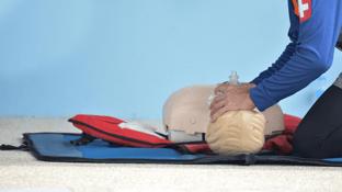 Medical professional placing a breathing tube on a dummy while performing Basic Life Support