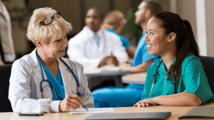 Director of Nursing interviewing a nurse at a table