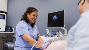 Female sonographer performing an ultrasound on a patient's stomach